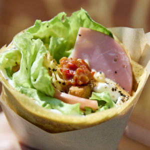 赤い神楽南蛮味噌をトッピングしたファーマーズカフェの米粉クレープ『南蛮ハムマヨチーズレタス』